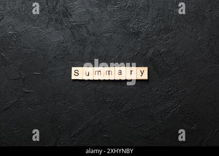 Sommario parola scritta sul blocco di legno. Il testo di riepilogo sulla tabella, concetto. Foto Stock