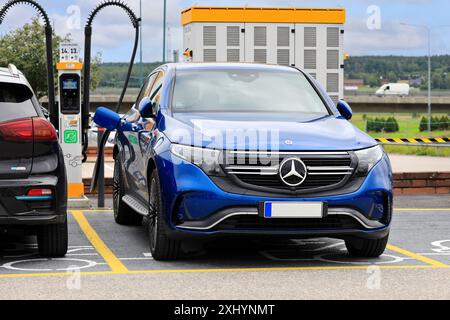 Batteria di ricarica blu per SUV elettrico Mercedes-Benz EQC 4-Matic presso il punto di ricarica pubblico. Salo, Finlandia. 14 luglio 2024. Foto Stock