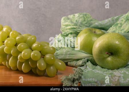 Due mele verdi, un grande mazzo di uva verde su un tavolo di legno. Una corretta alimentazione. dieta vitaminica. Peso in eccesso. Vegano. Bel corpo. Foto Stock