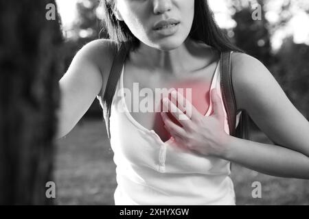 Attacco di cuore. Giovane donna che soffre di dolore al petto all'aperto, primo piano Foto Stock