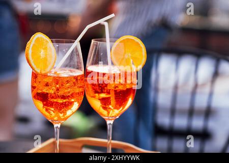 Due eleganti bicchieri da champagne su un gambo lungo su un vassoio Vino frizzante in tazze per due sul tavolo all'interno. Gustose bevande alcoliche con fette di limone A. Foto Stock