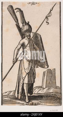 Incisione su legno di Melchior Lorck raffigurante un soldato in piedi che tiene uno scudo a manovella nella mano sinistra e una lancia nella destra, con una spada e un pugnale al suo fianco; sullo sfondo è riportato un obelisco in rovina o una torre quadrata, XVI secolo. Foto Stock