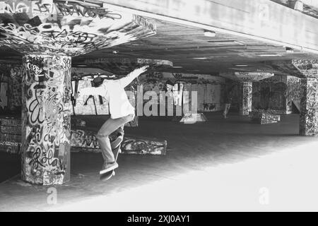 Skateboarder che tira trucchi sul suo skateboard ( bianco e nero ), Southbank skatepark ' Undercroft Skate Space ', Londra, Inghilterra Foto Stock