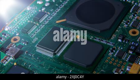 Primo piano dettagliato di una scheda a circuito stampato elettronica che mostra microchip, resistori e altri componenti, che rappresentano la tecnologia e l'hardware moderni. Foto Stock