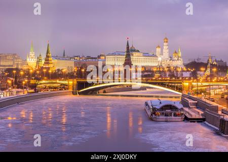 Cremlino di Mosca illuminato in inverno. Fiume di Mosca ghiacciato. Vista dal ponte patriarcale. Russia Foto Stock