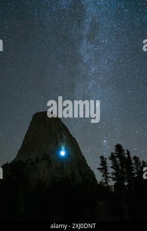 Blue Milky Way Over Devils Tower Butte a Clear Night. Luce di scalatori su un muro. Wyoming, Stati Uniti Foto Stock