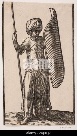 Incisione su legno di Melchior Lorck raffigurante un soldato in piedi rivestito di turbanti che regge una lancia nella mano destra e uno scudo curvo sul braccio sinistro, creata nel 1526-1583. Foto Stock