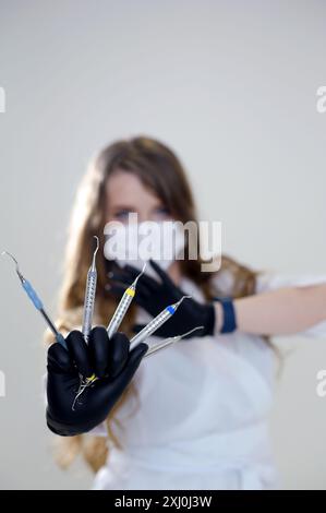 Modello di protesi e strumenti odontoiatrici nelle mani del dentista. Servizi odontoiatrici. Strumenti dentali in mano Foto Stock