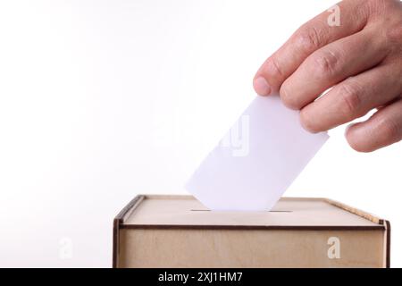 Uomo che mette il suo voto nelle urne su sfondo bianco, primo piano Foto Stock