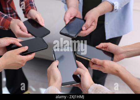 Persone che hanno smartphone con schermi vuoti all'interno, primo piano Foto Stock