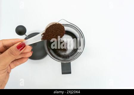 Preparazione di un caffè con uno stantuffo French Press, chicchi di caffè neri, sfondo bianco isolato Foto Stock