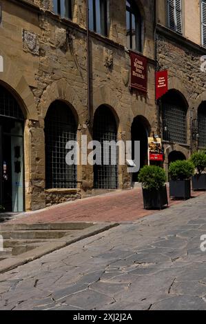 Palazzo medievale del Capitano del popolo ad Arezzo, Toscana, Italia, ora sede della Casa Museo Ivan Bruschi, un'eclettica collezione di arte e antichità. La proprietà, nota anche come Palazzo della Zecca dal suo uso come zecca dopo la resa di Arezzo a Firenze nel 1384, si trova su corso Italia. Fu la casa di Ivan Bruschi (1920 - 1996), fondatore della famosa fiera mensile dell'antiquariato di Arezzo, e oggi ospita la collezione eclettica di Bruschi. Foto Stock