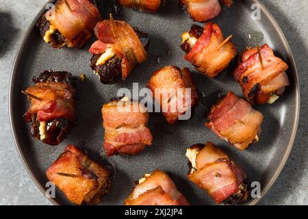 Datteri avvolti al pancetta caldo con formaggio di capra Foto Stock