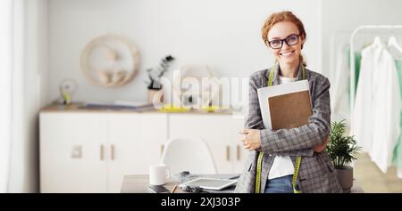 Giovane designer di abbigliamento nel suo studio di moda Foto Stock