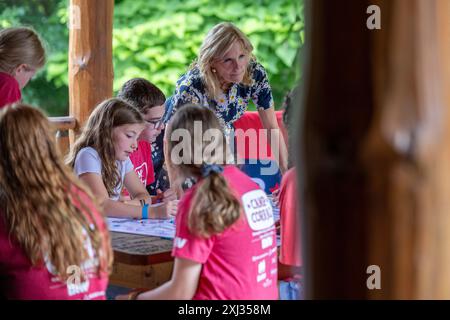 Middleville, Stati Uniti. 3 luglio 2024. La first lady Jill Biden visita con i bambini che lavorano a un progetto d'arte al YMCA Camp Manitou Lin Youth Development Center di Middleville, Mich., mercoledì 3 luglio 2024. Biden ha visitato un campo estivo di Hidden Helpers per riconoscere i bambini legati all'esercito di soldati feriti, malati o feriti o veterani come parte della sua iniziativa Join Forces. (Foto di Andrew Roth/Sipa USA) credito: SIPA USA/Alamy Live News Foto Stock