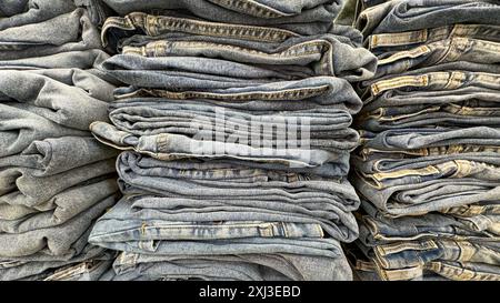 pile di jeans blu perfettamente piegate esposte in un negozio Foto Stock