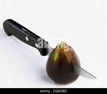 Taglio di una fig in due Foto Stock