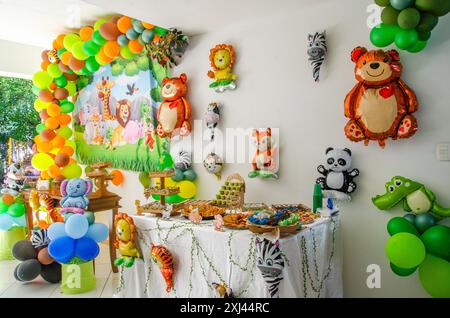 Festa di compleanno per bambini, decorazioni a tema zoo con baloon colorati, tavolo dei dolci e baloon animali Foto Stock