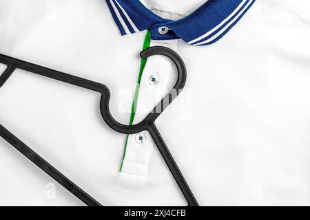 Comoda polo bianca dal design classico e alla moda e primo piano con gancio nero. Copia spazio Foto Stock