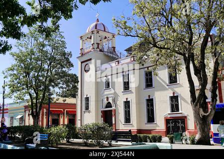 Città vecchia, Camagueey, Provincia di Camagueey, Cuba, America centrale, chiesa in stile coloniale con intonaco rossastro e imponente torre della chiesa circondata da Foto Stock