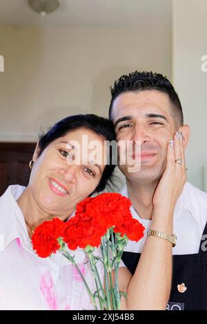 Centre, Santa Clara, Cuba, grandi Antille, Caraibi, America centrale, America, Un uomo e una donna vicini con un bouquet di fiori rossi Foto Stock