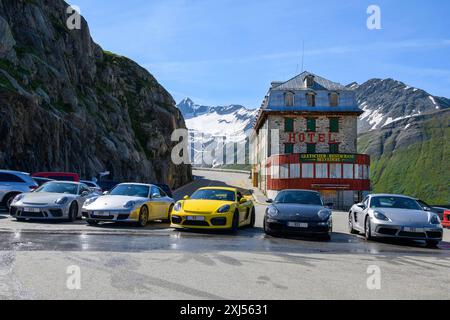 Cinque auto sportive Porsche parcheggiate di fronte all'ex hotel Gletscher-Restaurant Belvedere abbandonato sulla strada del passo Furka Berga Alpine Foto Stock