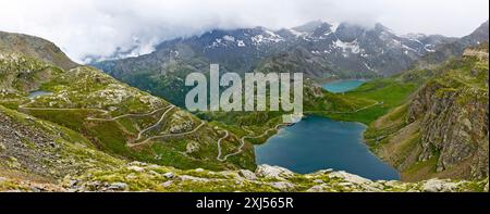 Vista panoramica dei serpenti di sinistra strette curve dal passo di salita al passo alpino Colle del col de Nivolet, lago di montagna di primo piano di destra Foto Stock