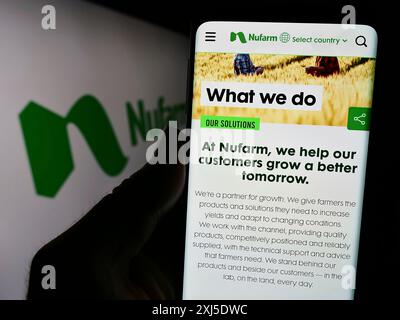 Stoccarda, Germania, 02-12-2024: Persona che detiene il cellulare con il sito web della società agrochimica australiana Nufarm Limited davanti al logo. Concentrati su Foto Stock