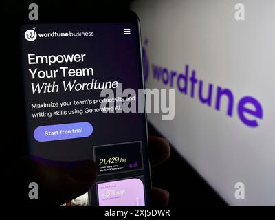 Stoccarda, Germania, 02-12-2024: Persona che tiene il cellulare con pagina web del compagno di intelligenza artificiale Wordtune (AI21 Labs) con logo. Concentrati su Foto Stock