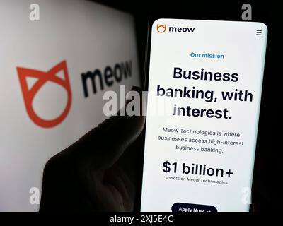 Stoccarda, Germania, 02-14-2024: Persona che detiene il cellulare con pagina web della società fintech statunitense Meow Technologies davanti al logo aziendale. Concentrati su Foto Stock