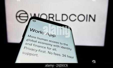 Stoccarda, Germania, 02-15-2024: Smartphone con sito web del progetto di criptovaluta Worldcoin (Tools for Humanity) davanti al logo aziendale. Concentrati su Foto Stock