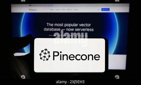 Stuttgart, Germania, 02-16-2024: Persona con smartphone con logo della società statunitense di intelligenza artificiale Pinecone Systems Inc. Davanti al sito web. Foto Stock