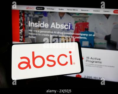 Stuttgart, Germania, 02-16-2024: Persona che possiede un telefono cellulare con il logo della società americana di ricerca di droga Absci Corporation davanti al business web Foto Stock