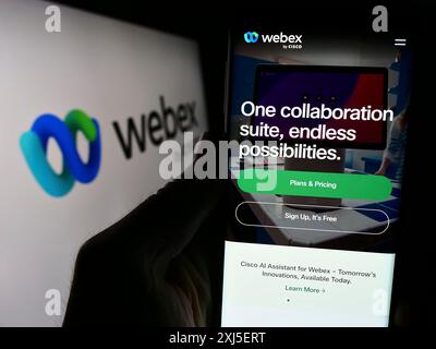 Stoccarda, Germania, 02-19-2024: Persona che detiene un cellulare con pagina web della società statunitense di comunicazioni unificate Webex by Cisco davanti al logo. Concentrati su Foto Stock