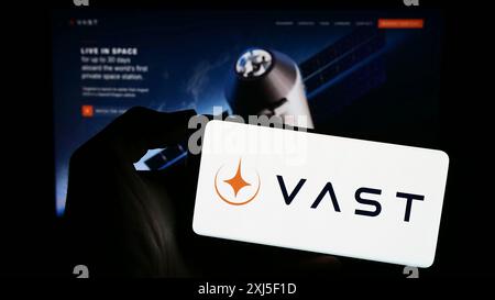 Stoccarda, Germania, 02-21-2024: Persona che detiene un telefono cellulare con il logo della società aerospaziale americana VAST Space LLC di fronte alla pagina web aziendale. Foto Stock