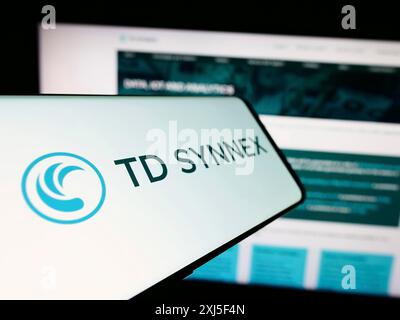 Stuttgart, Germania, 02-21-2024: Smartphone con logo della società americana di distribuzione IT TD SYNNEX Corporation davanti al sito Web. Concentrati su Foto Stock