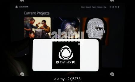 Stoccarda, Germania, 02-16-2024: Persona con smartphone con logo del gruppo di ricerca sull'intelligenza artificiale EleutherAI davanti al sito web. Concentrati Foto Stock