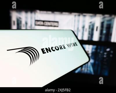 Stoccarda, Germania, 02-22-2024: Cellulare con logo della società americana di produzione di cavi Encore Wire Corporation davanti al sito web. Concentrati su Foto Stock