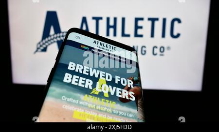 Stoccarda, Germania, 02-22-2024: Telefono cellulare con sito web della società statunitense di bevande Athletic Brewing Company davanti al logo aziendale. Concentrati su Foto Stock