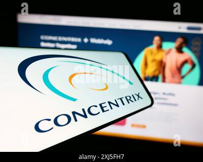 Stoccarda, Germania, 02-21-2024: Telefono cellulare con logo della società americana di servizi alle imprese Concentrix Corporation davanti al sito web. Concentrati su Foto Stock