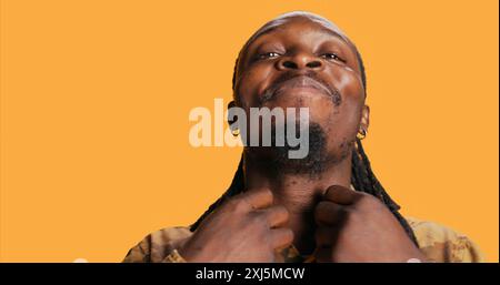 POV of african american Guy guarda il suo riflesso nello specchio, sistemando la sua barba e teme di essere sicuro e alla moda. Un adulto moderno si guarda e si sente bene. Scatto con cavalletto. Foto Stock