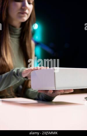 Gen Z Entertainment registra video di unboxing di vari componenti elettronici, presenta funzionalità agli spettatori, primo piano. Teenager Internet star che mostra consigli sui prodotti ai fan sui social media Foto Stock