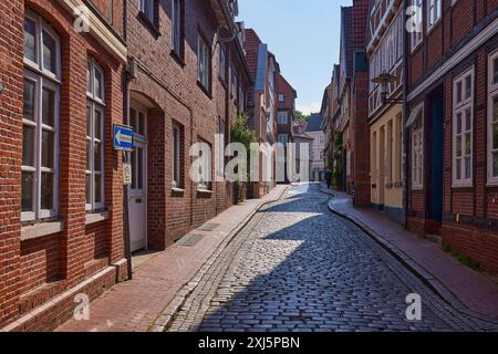 Strada acciottolata con edifici in mattoni alla luce nel centro storico di Stade, città anseatica, quartiere di Stade, bassa Sassonia, Germania Foto Stock