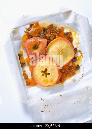 Mela con frutta secca e miele cotta in carta cerata Foto Stock