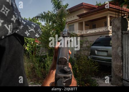 15 luglio 2024, Port-Au-Prince, capitale-National, Haiti: Membro armato di una banda per le strade della capitale haitiana, Port-au-Prince, che le bande ora controllano. Il Consiglio di sicurezza delle Nazioni Unite ha appena approvato all'unanimità una risoluzione che condanna "šÃ„Ãºin i termini più forti" "šÃ„Ã¹ la crescente violenza delle bande e l'attività criminale ad Haiti che sta minando la pace, la stabilità e la sicurezza nel paese e nella regione. La risoluzione di venerdì 12 luglio esprime grave preoccupazione per il flusso illegale di armi e munizioni in Haiti e per il loro legame con l'espansione del controllo territoriale da parte di bande e šÃ„Ãºthe Extreme l Foto Stock