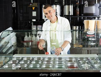 Venditore sorridente che offre rinfrescante tè boba taiwanese Foto Stock