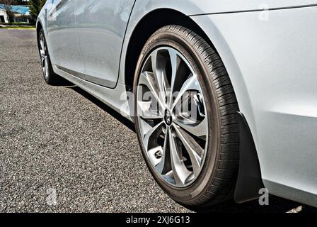 Una vista ad angolo basso di una Sonata Hyundai 2013 argentata dalla ruota posteriore alla parte anteriore, in basso a sinistra. Il capovolgimento orizzontale ha un aspetto simile al lato destro. Foto Stock