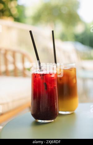 Primo piano di un caffè ghiacciato e di una bevanda alla limonata di frutta su un tavolo da caffè all'aperto in estate Foto Stock