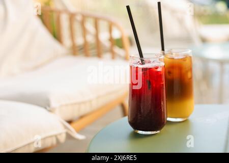 Rinfrescanti drink estivi in bicchieri alti con cannucce sul tavolo, sulla terrazza estiva. Foto Stock