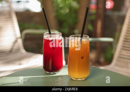 Primo piano di un caffè ghiacciato e di una bevanda alla limonata di frutta su un tavolo da caffè all'aperto in estate Foto Stock